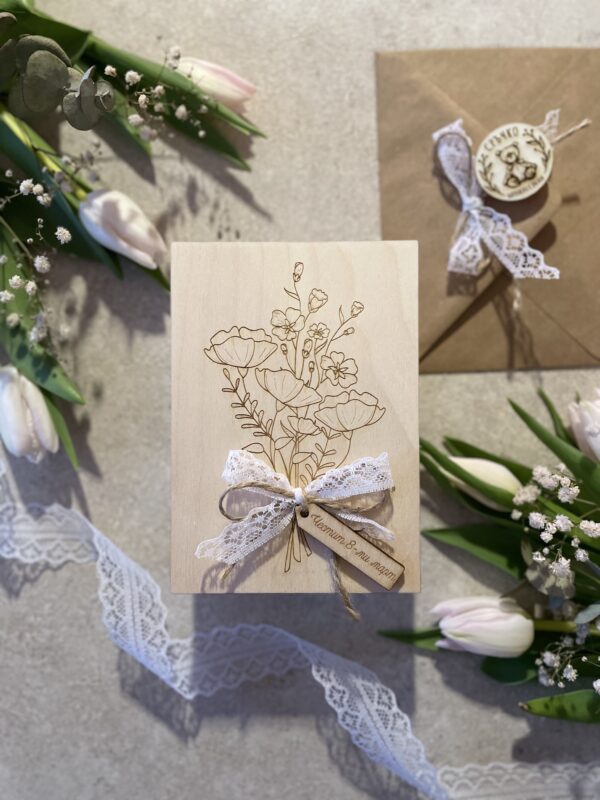 Изображение на дървена картичка с красив букет от полски цветя и нежна дантелена панделка.